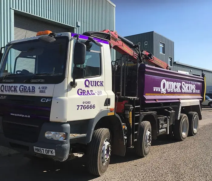 Quick Skips grab hire lorry loading waste on site in Westbourne, Dorset